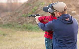 Man shooting pistol with son