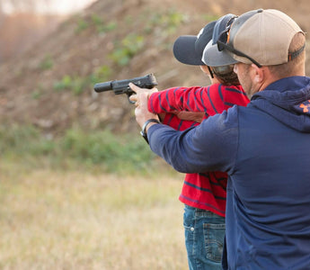 Man shooting pistol with son