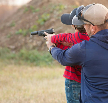 Man shooting pistol with son