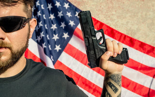 man in sunglasses holding a gun