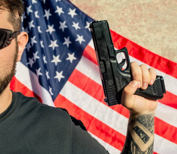 man in sunglasses holding a gun