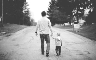 man walking down the street with a child