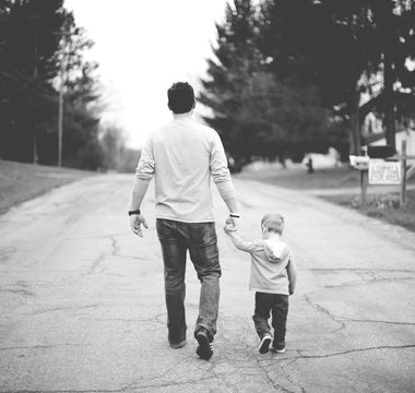 man walking down the street with a child