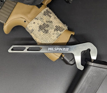 MILSPIN Glock mag base plate removal tool on top of Glock grip and mag