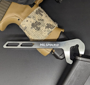 MILSPIN Glock mag base plate removal tool on top of Glock grip and mag