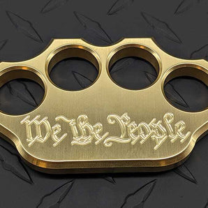 top-down view of “We The People” novelty brass knuckle paperweights
